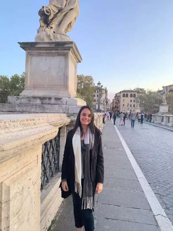 Jessica standing on a sidewalk in front of a statue and smiling